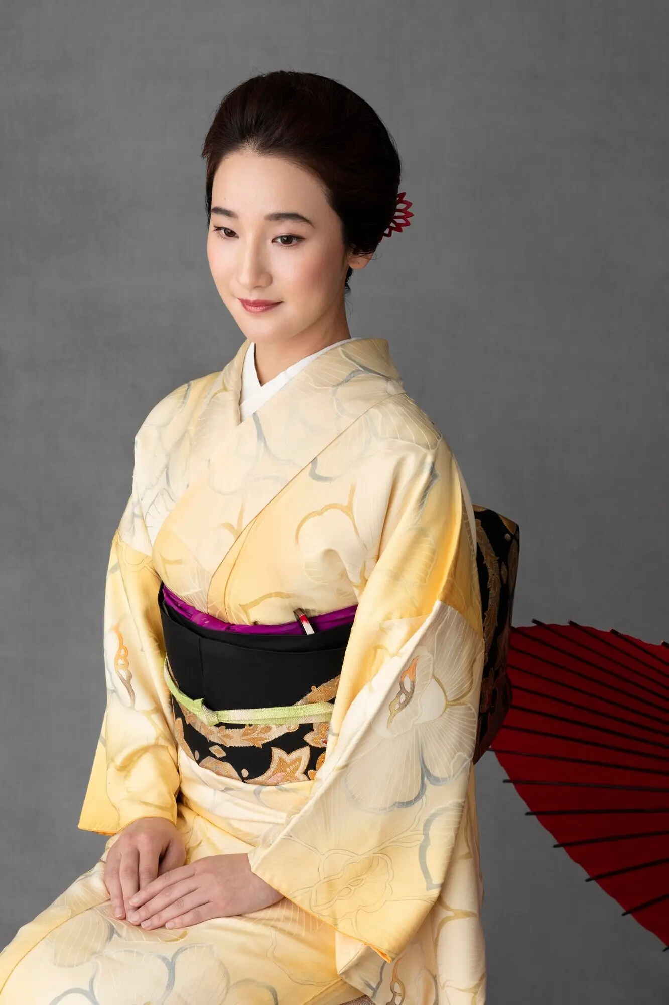 Hübsches japanisches Model mit einem roten Regenschirm